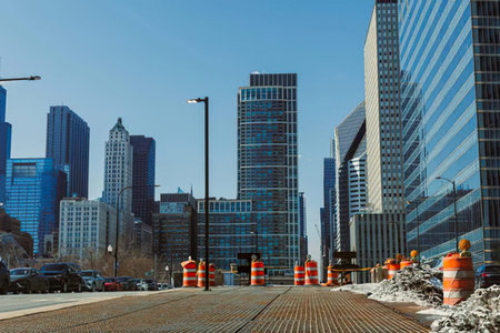 A city street scene with skyscrapers, cars, and a bright blue sky