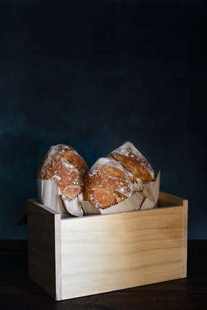 Baked bread of sourdough. French loaves of bread in wooden box. The bread of sourdough, homemade and natural creation. The sourdough has natural yeast, which makes the food healthier, as well as rich.の写真素材