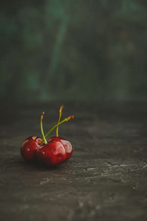 Three cherries on dark background. Close-up.の写真素材