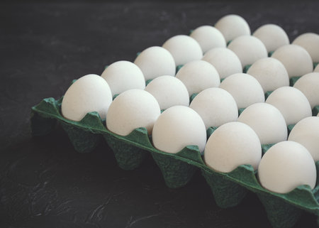 Chicken eggs in a cardboard box. White eggs and green cardboard.の写真素材