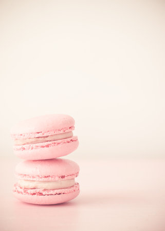 Pink macarons. Vertical photos. Delicious macaroons. Stack of two macarons on pink background. Light background.の写真素材