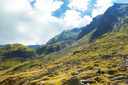 Romanian Carpathian mountains on a summer sunny day. Amaizing view from down up on the mountains and cloudy sky near Transfagarasan alpine mountain road, Fagaras Mountains, Transylvania, Romaniaの写真素材