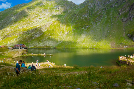 Balea Lake, Romania - August, 2019: Transfagarasan Balea glacier lake in the Fagaras Mountains, in central Romania, Sibiu County. Unidentified tourists enjoy the sights of Balea Lake. Eastern Europe.のeditorial素材