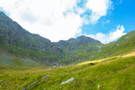 Romanian Carpathian mountains on a summer exciting travel. Amaizing view from down up on the mountains and cloudy sky near Transfagarasan alpine mountain road, Fagaras Mountains, Transylvania, Romaniaの写真素材