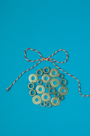 Christmas ball from washers and nuts on blue paper. Metal nuts. washers and grovers. Industrial new year concept background. Christmas card holiday greetings.の写真素材