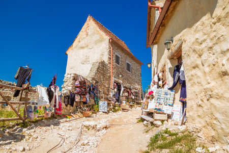 Rasnov, Romania - August, 2019: Inside courtyard, old houses and souvenir shops of The Rasnov Citadel - a medieval fortress in traditional romanian style near the town of Brasov. Transylvania. Summer.のeditorial素材