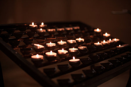 set of lighted candles in church. Hope, praying concept. Tranquility in religion. Romantic scenery for dates.の写真素材