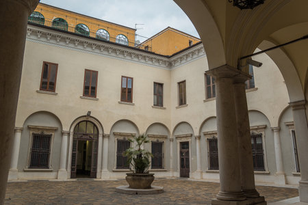 Brescia, Italy - December, 2015: the courtyard of a beautiful house with a palm tree in a pot in the middle of it. Romantic patio in italian villa in Brescia city. Lombardia. Europe.のeditorial素材