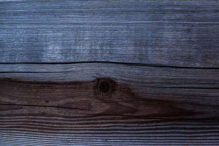 weathered dark wood background with texture. Texture of brown and grey old wood. Wide burned board texture close-up. a wooden surface.の写真素材