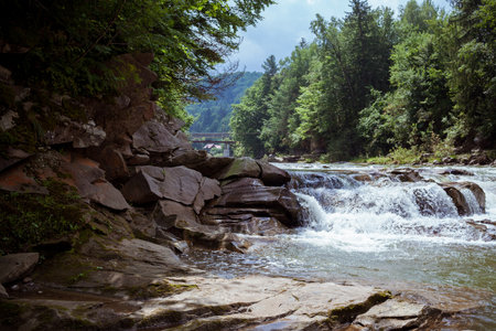 Splashing Waterfall in Carpathian mountains. Relaxing view in the forest. Rocky waterfront near scenic river.の写真素材
