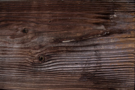 weathered dark brown wood background with texture. Texture of brown old wood. Wide burned board texture close-up. a wooden pattern.の写真素材