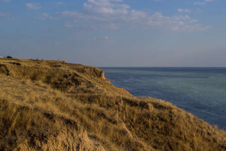 Amazing golden time panoramic view of Stanislav clay mountains and canyons above Dnipro river bay near the Black sea, Ukraine, Kherson Grand Canyon. Yellow clay cliffs and hills covered by dry grass.の写真素材