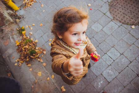 little girl holding a red flower in her hand.の写真素材