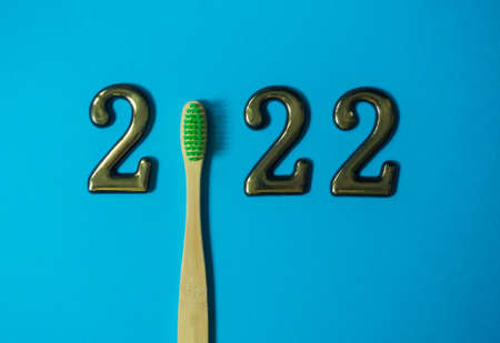 2022 and dental concept. Close up view photo with 2022 and wooden green toothbrush instead zero on...