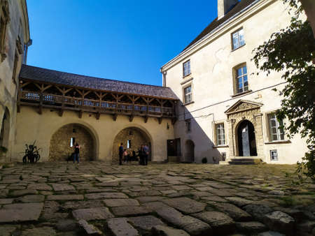 Olesko, Ukraine - October, 2019: Olesko Castle Courtyard in sunny autumn day. Tourists walking in Olesko Castle yard admiring ancient architecture view. Travelling in Lviv region of Western Ukraine.のeditorial素材