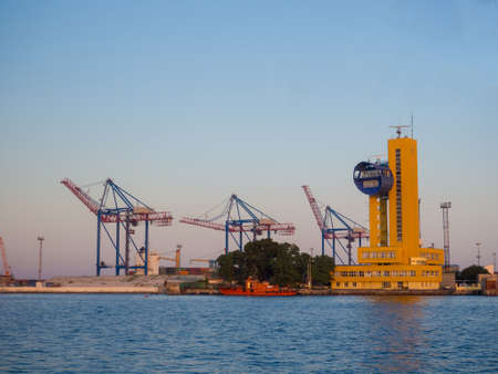 Odesa, Ukraine - July, 2021: Marine Industrial Commercial Port of Odessa with cranes, containers, ship. Cargo container terminal of sea freight industrial port. Sea freight, container cranes.のeditorial素材