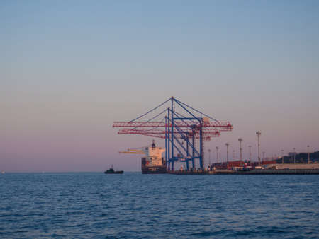 Odesa, Ukraine - July, 2021: Marine Industrial Commercial Port of Odessa with cranes, containers, ship. Cargo container terminal of sea freight industrial port. Sea freight, container cranes.のeditorial素材