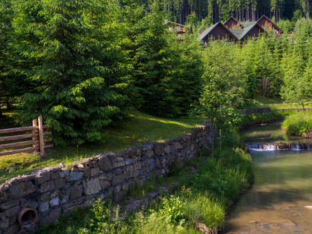 Fortified shore of stone. Small river with rapids in Bukovel, Ukraine. Sights of the modern popular ski resort of Bukovel.の写真素材