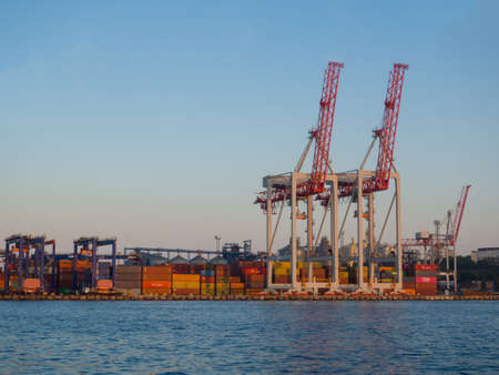 Odesa, Ukraine - July, 2021: Marine Industrial Commercial Port of Odessa with cranes, containers, ship. Cargo container terminal of sea freight industrial port. Sea freight, container cranes.のeditorial素材