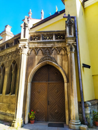 Amazing big old arched two-leaf wooden door under a semicircular arch of stone. Brown door with a ornate gothic elements. Sts. Peter and Paul Cathedral, Kamianets-Podilskyiの写真素材