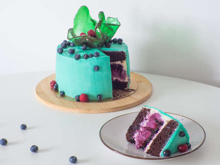 Green blueberry cake with caramel vase on white background. Birthday cake with cream cheese...
