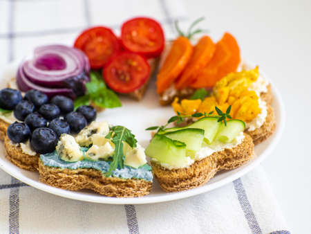 Rainbow sandwiches heart shape on white table. Breakfast bread rainbow sandwiches with colorful vegetables. Love, Valentines day food and LGBT pride flag concept. Copy space. Top view. Healthy food.の写真素材