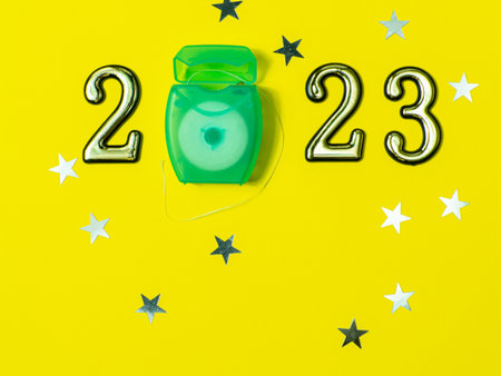 2023 and dental concept. Close up view photo with 2023 and green dental floss instead zero on yellow...