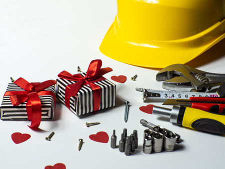 Construction tools and 2 gifts on white background with small red hearts and copy space. Construction greeting card for Valentines day. Repair home with love. Gifts for lover. Buying presents for man.の写真素材