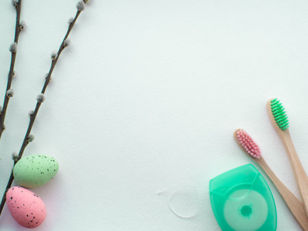 Happy Easter and dentist concept. Wooden toothbrushes with Easter decorations on white background. Dentist Easter greating card with copy space. Top view, flat lay. Toothbrushes, eggs and dental flossの写真素材