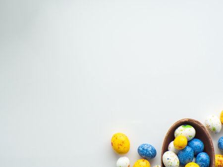 Sweet Easter concept. Blue, white and yellow chocolate easter eggs with sweets on white background...