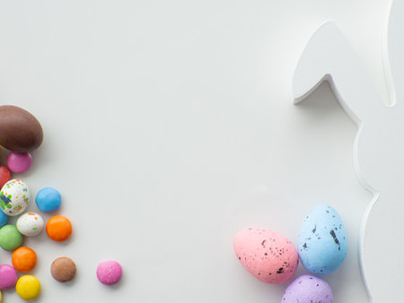 Sweet Easter concept. Colorful and chocolate easter eggs with sweet dragee on white background with...