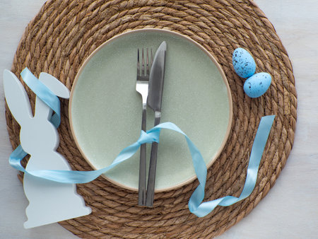 Festive Easter table setting with eggs and bunny on light background, flat lay. Elegance pastel and...