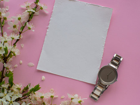 Womens hand watch on pink background with cherry flowers and copy space. Womens, Valentines and Mothers Day gift. Concept of beauty, elegance and femininity. Buying birthday gifts online.の写真素材