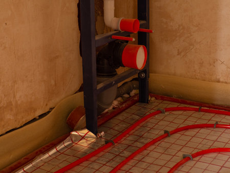 Installing heating and water pipes in apartment. Installing concealed toilet frame in bathroom. Maintenance jobs for water and heating systems. Concept of plumbing and home renovation.の写真素材