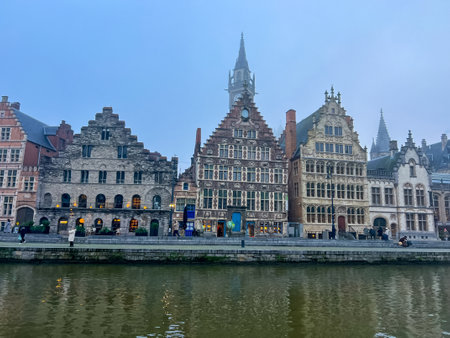Ghent, Belgium, November 2023: View of the historic belgian city of Ghent featuring charming medieval buildings and canal running through city center, creating a stunning waterfront scene in foggy dayのeditorial素材