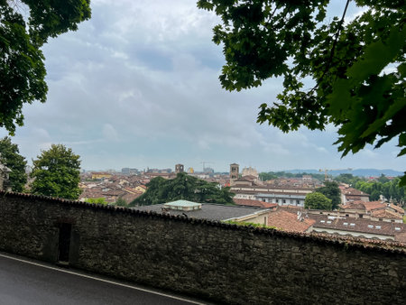 Aerial panoramic view of old historical city centre of Brescia city with churches, towers and medieval buildings with red tiled roofs, Lombardy, Northern Italy. Panorama of Brescia on rainy weather.の写真素材