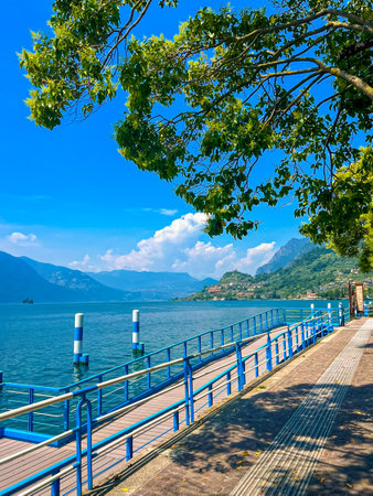 Ferry dock in the town of Sale Marasino on sunny summer day. A small pier along the shore of Lake Iseo, Lombardy, Italy.の写真素材
