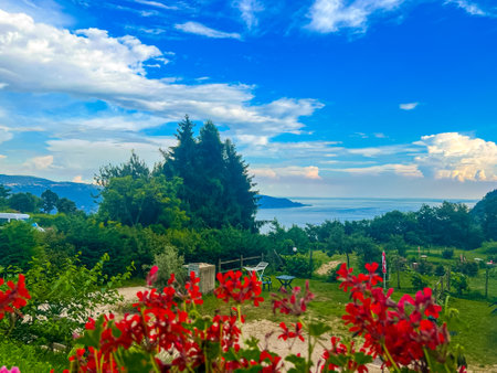 This picturesque campsite by the lake provides a tranquil escape. Enjoy stunning views, lush greenery, and a peaceful atmosphere, ideal for unwinding and connecting with nature. Italy, Garda lake.の写真素材