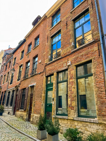 A charming old townhouse in Brussels featuring vibrant green doors and striking red brick walls, showcasing classic european architecture. Perfect for travel and historic content. Belgiumの写真素材