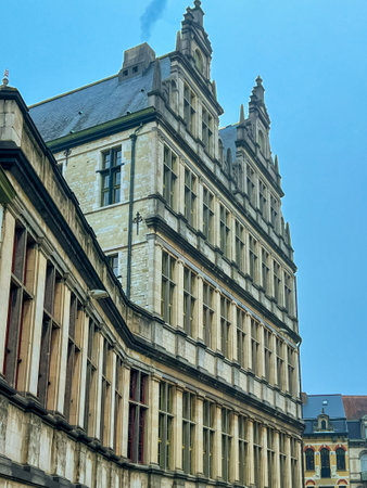 Capture the architectural beauty of the town hall in Ghent, featuring its intricate stone facade set against a vibrant blue sky, perfect for showcasing historical landmarks. Belgiumの写真素材