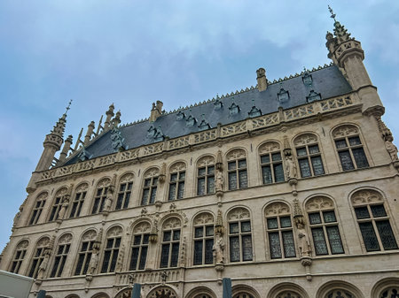 This captivating close-up showcases a historic building in Leuven, featuring numerous windows and intricate stone or marble details. The architectural design captures the old-world charm and beauty.の写真素材