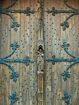 A captivating close-up of an aged wooden church door, showcasing intricate ironwork details and weathered textures, evoking a sense of history and craftsmanship.の写真素材