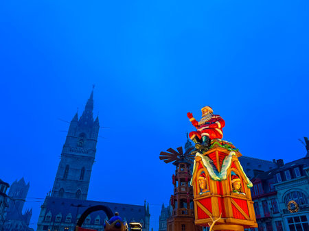 A stunning and vibrant christmas decoration adorns the town hall in Ghent, showcasing a huge, illuminated figure against a clear blue sky, creating a festive atmosphere during the holiday season.の写真素材
