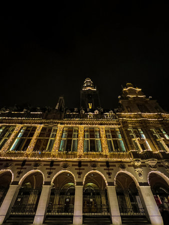 A stunning nighttime photograph of Leuven universitys grandiose hall, beautifully illuminated by...