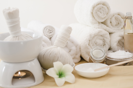 Spa treatment with towels and herbal creams and scrubs on beautiful soft bakcgorundの写真素材