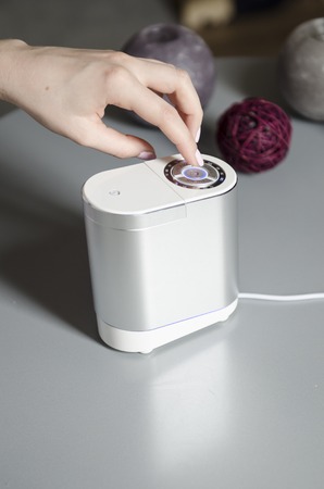 woman turn on air humidifier on the tableの写真素材