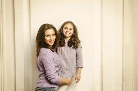Happy mother and child girl posing in studioの写真素材