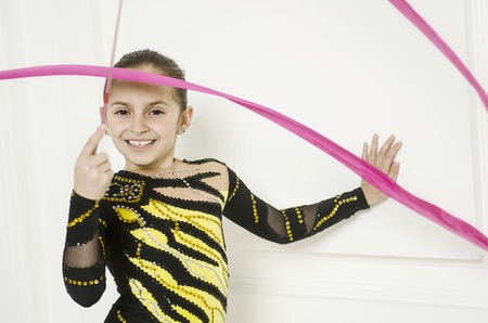 Beautiful sport training rhythmic gymnastic girl posing in studioの写真素材
