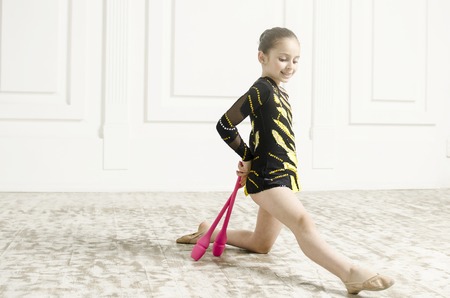 Beautiful sport training rhythmic gymnastic girl posing in studioの写真素材
