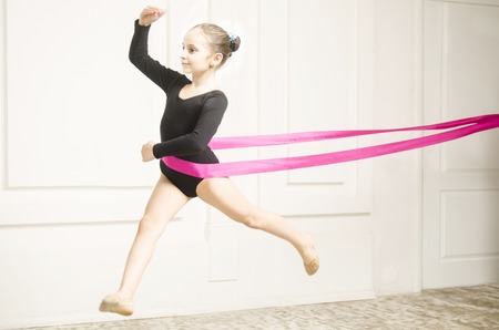 Beautiful sport training rhythmic gymnastic girl posing in studioの写真素材